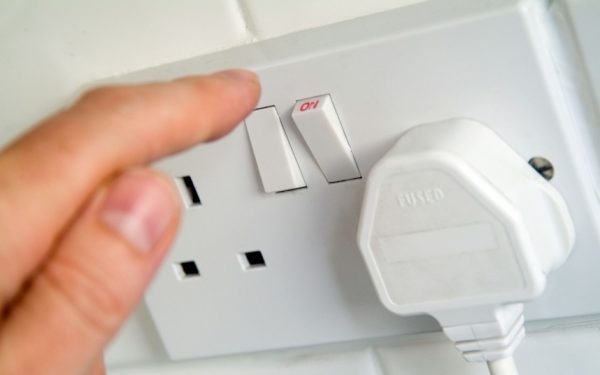 a person turning on a switch in the socket