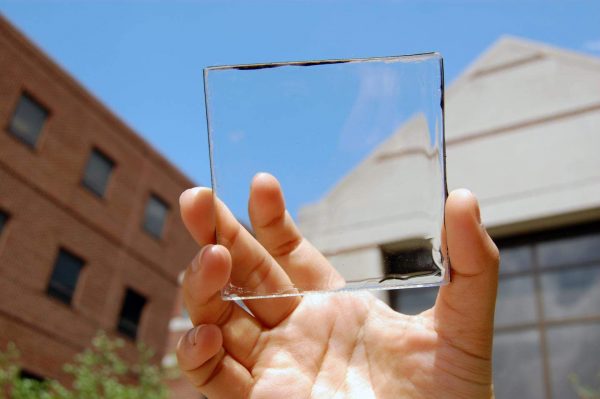 a man holding a clear square tile