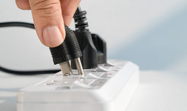 a hand plugging a wire into an extension cord