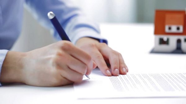 a businessman signing a contract for a housing loan